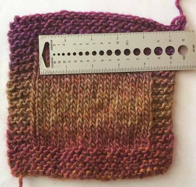 A knitted swatch with a ruler laid across the center, stockinette section to show the tension at 16 stitches over 4".