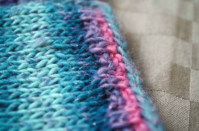 Close-up of neckline and waistband edging featuring k2 p2 one row and garter stitch on the next row for 4 or 6 rows