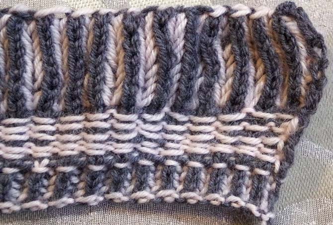 The charcoal gray Bella Cash stands out on the the wrong side of a brioche swatch with the corrugated ribbing showing.