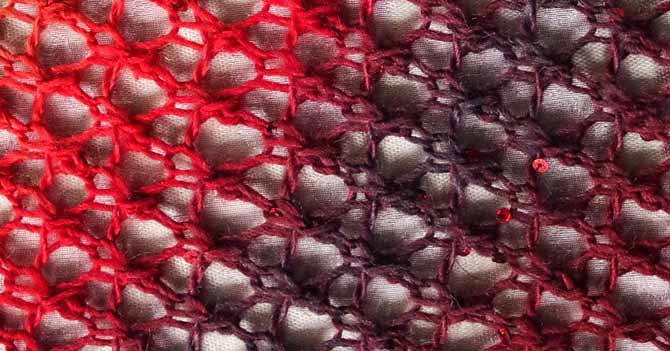 A bird's eye view of this easy lace that shows off the gradient yarn moving from coral to merlot to plum and back again