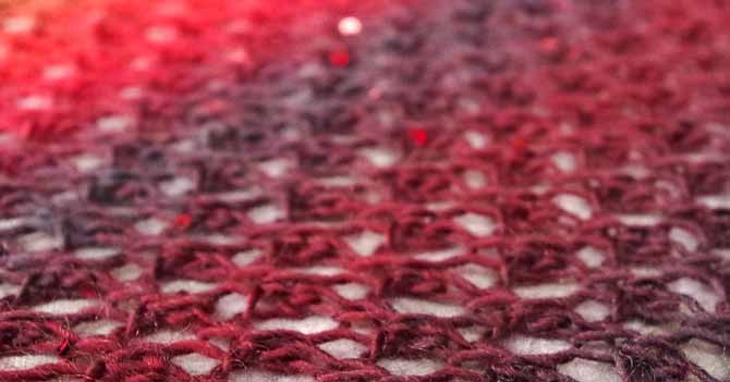 A close-up of the lace scarf with the sequins glinting in the blurred background of the photo