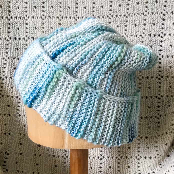 The garter stitch hat is modelled on a mannequin, front, side and back view