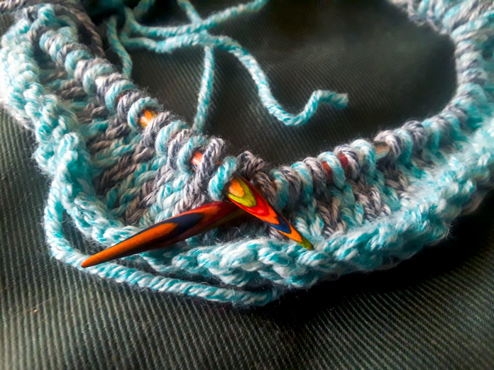 The start of the Holland Cowl on a set of Knit Picks Rainbow Wood Circular Needles. The cowl is done in a slip-stitch pattern using two colours of Mystical Marl yarn in Lagoon and Midnight.