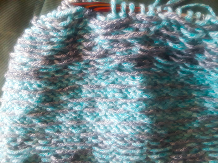 The Wrong Side of a Holland Cowl, knit in Universal Yarns Mystical Marl on a set of Knit Picks Rainbow Wood Circular Knitting Needles. The various yarns carried on the wrong side of the stranded colorwork are clearly visible.