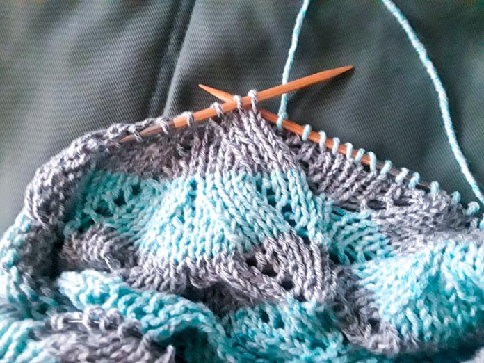 The Sunshine Throw Worsted Blanket on the needles with two colors of Mystical Marl Yarn