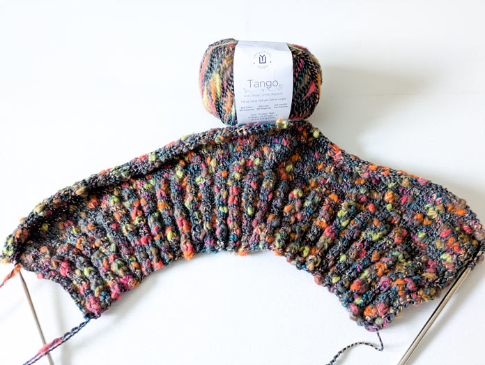 The beginning of the work on the back of the Lawson Cardigan and a ball of UNIVERSAL YARN Tango multicolor cotton blend.