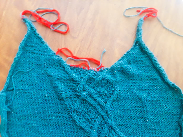 Flat-lay of the Palomar Top before final finishing, with neckline and shoulder stitches held on scrap yarn.