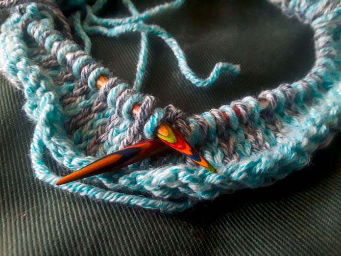 The start of the Holland Cowl on a set of Knit Picks Rainbow Wood Circular Needles. The cowl is done in a slip-stitch pattern using two colours of Mystical Marl yarn in Lagoon and Midnight.