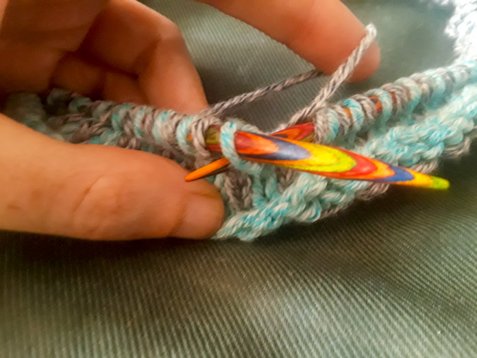 The Holland Cowl in progress on a set of Knit Picks Rainbow Wood Circular Needles. The cowl is done in a slip-stitch pattern using two colours of Mystical Marl yarn in Lagoon and Midnight.