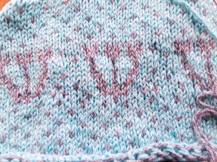 A Holland Cowl in progress on a set of Knit Picks Rainbow Wood Circular Needles. It’s knit in two colors of UNIVERSAL YARN Mystical Marl. The Midnight color seems to pop into the foreground.