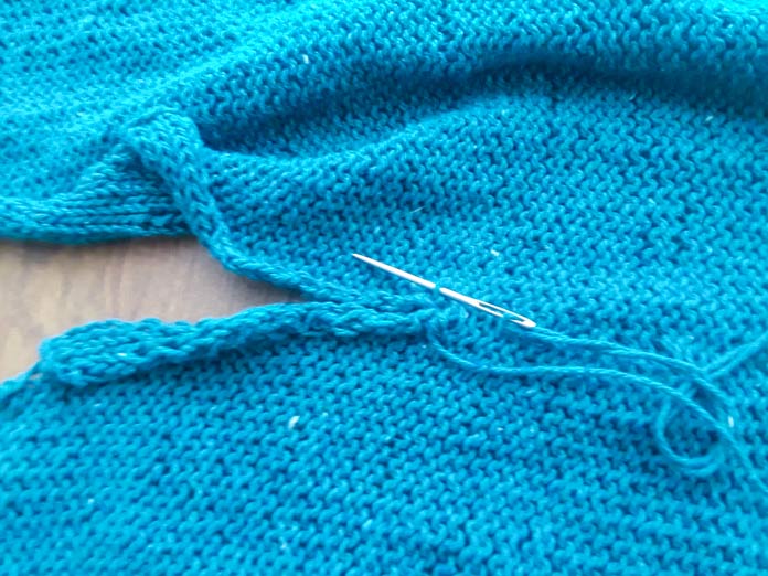 Close-up of mattress stitch seaming on the side of the Palomar Top using a Unique Knitting Round Tipped Needle.