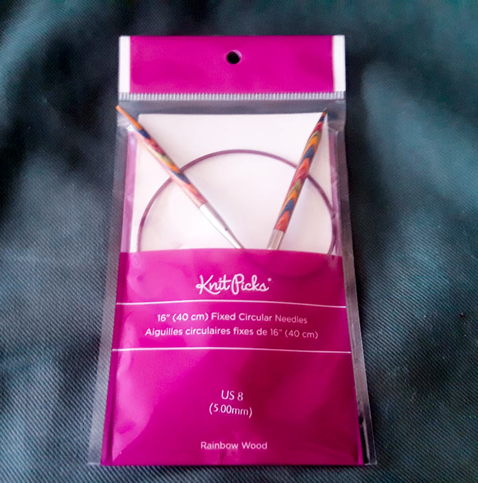 A set of Knit Picks Rainbow Wood 5mm Circular Knitting Needles, still in their packaging.