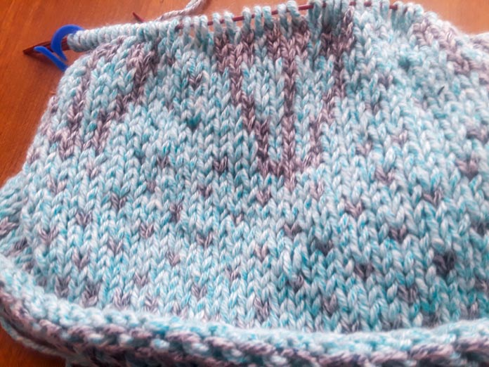 A Holland Cowl in progress on a set of Knit Picks Rainbow Wood Circular Needles. It’s knit in two colors of UNIVERSAL YARN Mystical Marl. The Midnight color seems to recede into the background compared to the Lagoon.