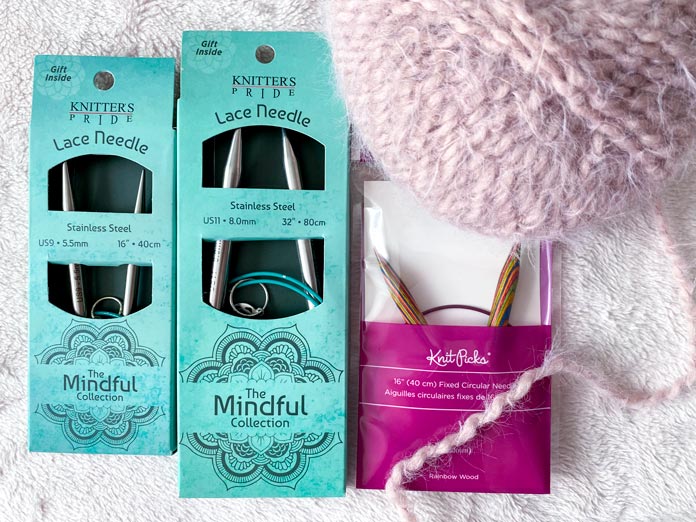 KNITTER’S PRIDE The Mindful Collection and Knit Picks Rainbow Wood knitting needles and a ball of UY Bella Bounce yarn