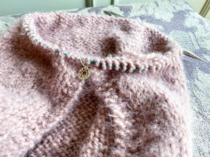 A knitted garment with a stitch marker