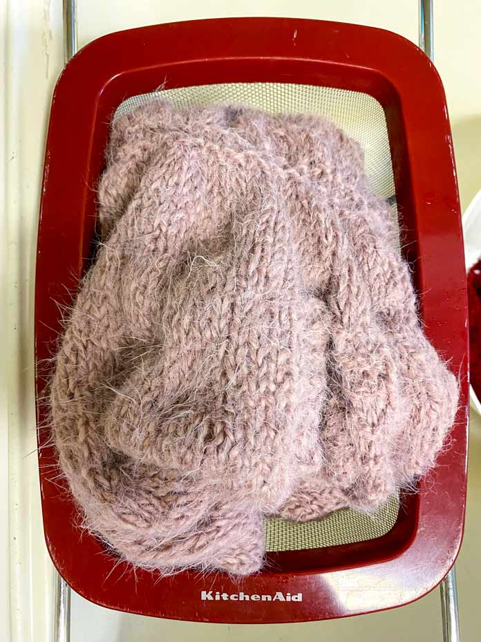 The Bubble Sleeve Shrug in a colander over a sink