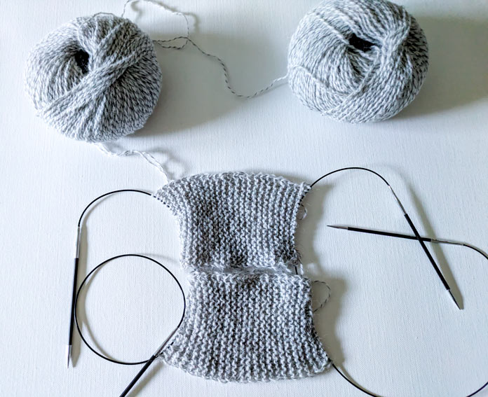 Two garter stitch knitted pieces on the knitting needles