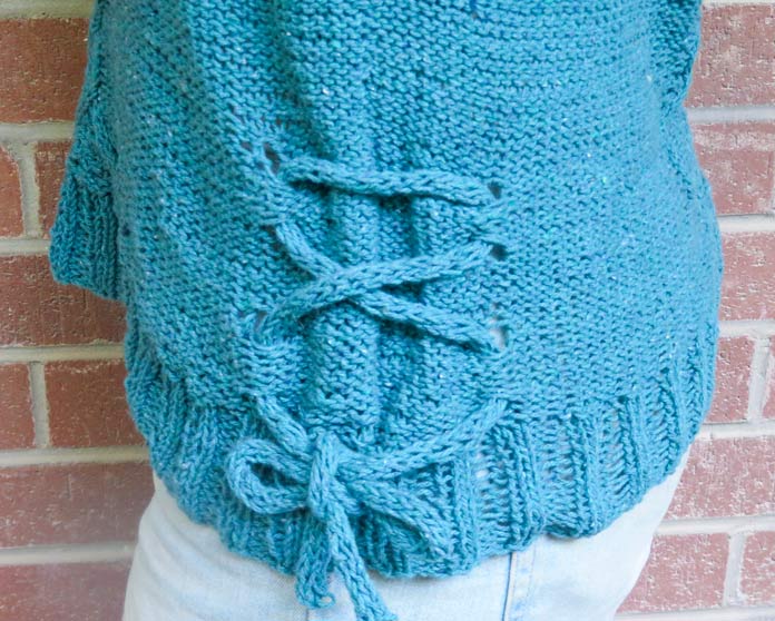 I-cord threaded through hemline eyelets on the Palomar Top, tied into a bow.