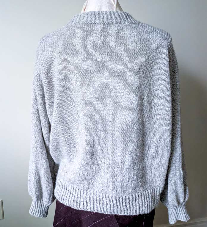 Back view of a V-neck knitted cardigan on a mannequin