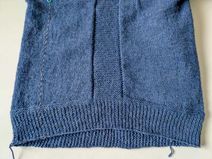 A knitted pullover in blue yarn with a curved hemline and a broken rib hem; Yarn Reviews, UNIVERSAL YARN, Fawning, KNITTER’S PRIDE LANTERN MOON, LANTERN MOON fixed circular needle, free knitting patterns, double stitch short rows, notions, knitting needles, knitted pullovers