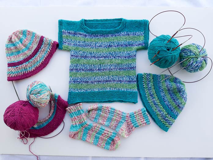 The finished socks in Universal Yarn Bamboo Pop Sock in Wildflowers, and a T-shirt in Morning Glory as the stripes and Equator as the solid, with a matching hat. The Wildflowers and Jam version is in progress; Knit Picks Fixed Circular Needles