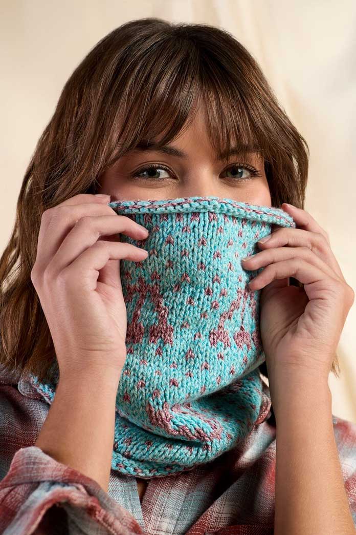 A lady wearing a colorful knitted cowl.