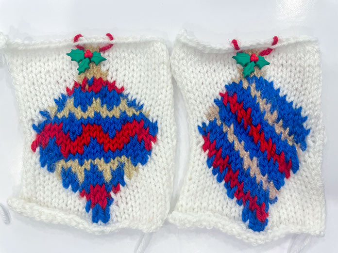 Two knitted Christmas ornament bulbs made with UNIVERSAL YARN Uptown DK and Noelle yarns with holly leaf embellishment.