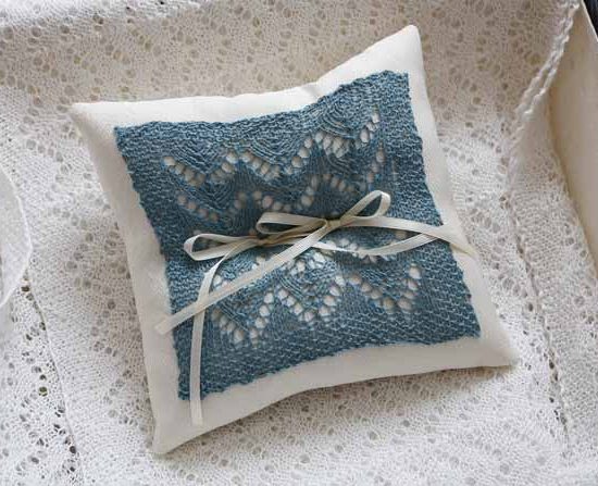 Ring bearer pillow for weddings made with a lace motif on a knitted swatch with 2 ribbons on it using Universal's Flax Lace yarn in mineral