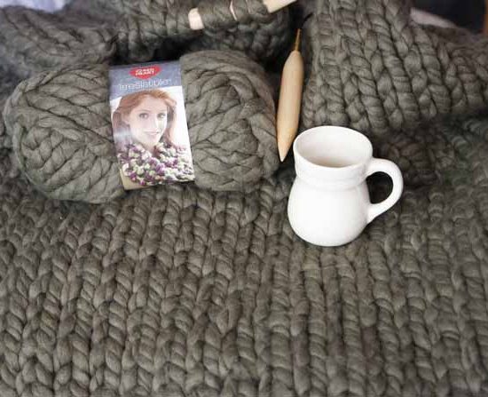 My daughter’s blanket is very soft and textured at the same time. I placed a cup of 11oz to show you how big the ball of yarn is, and how big the knit is too. Red Heart Boutique Irresistible yarn in Taupe