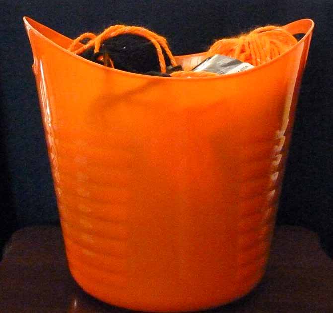 An orange pail with the supplies needed to complete the project