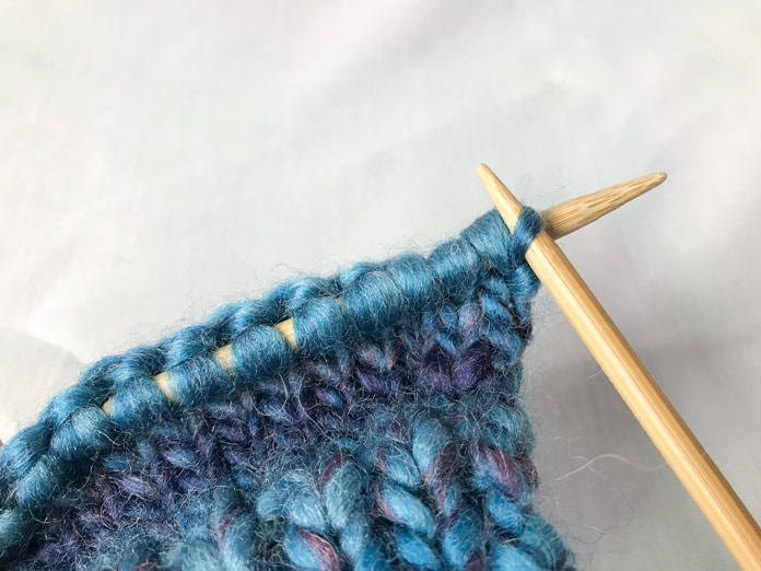 See how the first stitch is split on the needle? Also the rest of the stitches are wider than you would think. Be mindful when knitting with any roving or roving-like yarn.